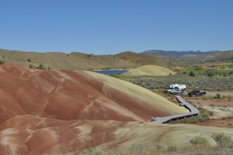 Parking lot and wooden path surrounded by colored hills, John Day Fossil Beds National Monument,