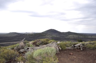 Barren lava landscape with hills under cloudy sky, Craters of the Moon National Monument, Idaho,