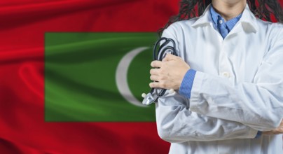 Healthcare professional with Maldives flag background. Professional doctor holding stethoscope on
