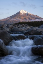 Mount Taranaki in the evening at sunset, in the foreground Stony River (Hangatahua River), Egmont