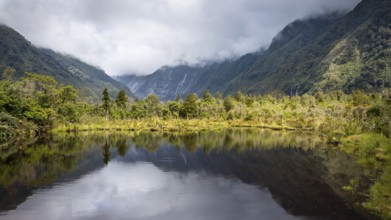 Peter's pool, glacier valley, mountains and glaciers in clouds. Westland Tai Poutini National Park,