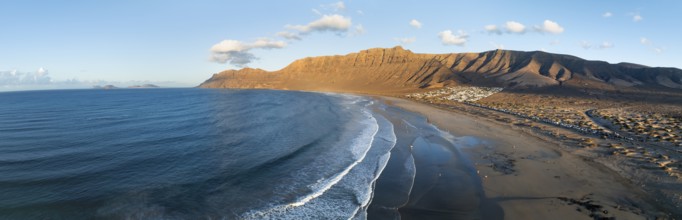 Panorama, Risco de Famara cliffs and sea with Famara beach, in the evening light, Playa de Famara,