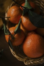 A close-up image capturing juicy oranges with vivid green leaves, nestled within a rustic woven