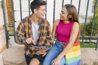A joyful lesbian couple enjoys a happy moment outdoors, sharing smiles and warmth. They represent