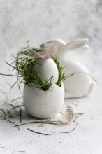 Featuring a softly textured Easter egg nestled in vibrant green grass, adorned with a delicate