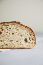 Close-up detail of a freshly cut slice of sourdough bread, showcasing its airy texture and crusty