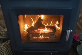 A wood burning stove with bright flames consuming logs, showcasing the warmth and rustic charm of