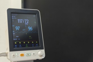 A mature woman is being monitored for vital signs like heart rate and blood pressure in a hospital