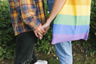 A touching close-up of a lesbian couple holding hands, symbolizing love and unity. One partner