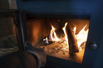 A close-up view of a vibrant fire within a blue wood burning stove, as cropped unrecognizable