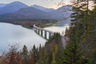 A scenic view of the Faller-Klamm Bridge spanning a tranquil lake in the Bavarian Alps Surrounded