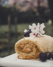 A close-up view of a Swiss roll filled with creamy dulce de leche, garnished with grapes, and