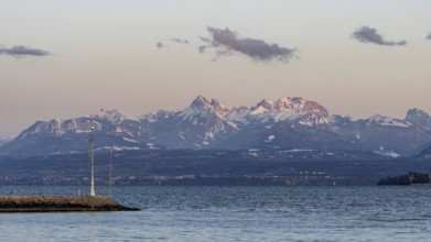 A breathtaking view of the snow-capped Swiss and French Alps seen from the shores of Lake Leman in