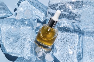 A serum bottle with a dropper is elegantly placed amidst scattered ice cubes, showcasing a