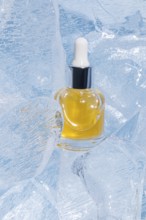 A single serum bottle filled with golden liquid, encased gracefully in cracked, transparent ice,