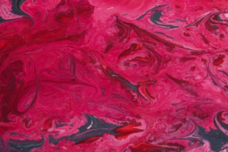 A striking abstract marble texture featuring vivid shades of acrylic red and pink, intertwined with