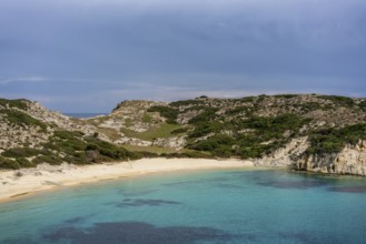 Kalamitsi Beach in Greece offers a serene setting with turquoise waters, golden sand, and a rugged,