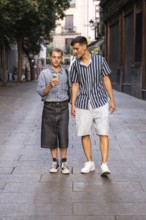 Stylish gay couple walking hand in hand on a quiet street in Madrid, Spain. One checks their