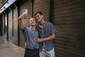 A joyful gay couple taking a selfie on the lively streets of Madrid. They express love and