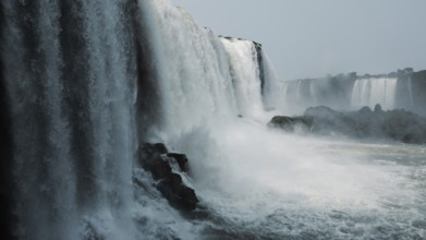 Stunning capture of the powerful Iguazu Falls surrounded by mist and plunging into the river at the
