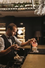 A skilled bartender expertly prepares a cocktail in a stylish bar, showcasing precision and