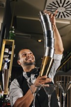 A professional bartender skillfully performs with cocktail shakers in a stylish bar. His expert