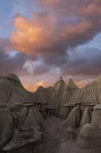 Surreal landscape at sunset featuring the unique hoodoos of Bisti/De-Na-Zin Wilderness in New