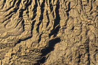 Aerial photograph showcasing intricate golden desert textures at Caineville Mesa, Utah. The