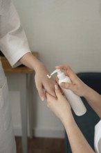 A mother and daughter engage in a relaxing skincare routine, applying lotion in a cozy home