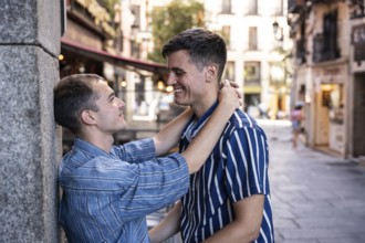 A gay couple shares a tender embrace on the streets of Madrid, showcasing love and connection in a