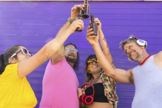 A joyful group of LGBTQIA+ friends toasting with drinks in celebration. Diverse individuals express