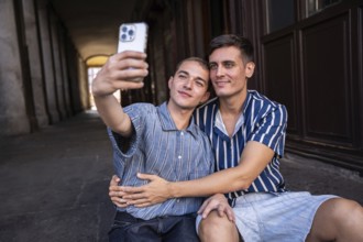 A joyful gay couple captures a selfie moment on the lively streets of Madrid. Embracing love and