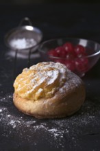 A freshly baked cream bun generously topped with a layer of velvety cream and dusted with icing