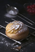 A delectable freshly baked cream bun, generously filled with smooth cream and dusted with fine