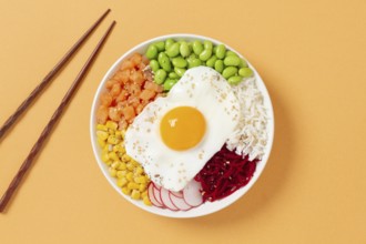 A colorful poke bowl featuring fresh ingredients like edamame, corn, salmon, beets, and a sunny