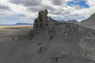 A dramatic view of towering rock formations in a vast desert landscape in Hanskville, Utah. The