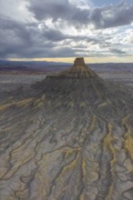 Aerial view of a rugged desert landscape, with intricate textures and eroded landforms under a