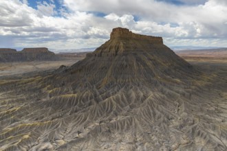 A striking aerial view of a weathered plateau with deep ridges and a barren landscape, under a