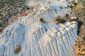 Aerial view of stunning white rock formations resembling waves in an arid landscape in White Pocket