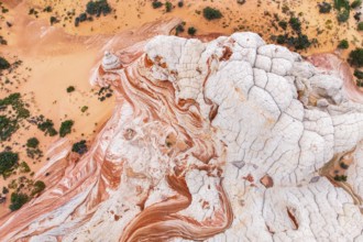 Aerial view captures white sandstone formations contrasting with the orange desert landscape,