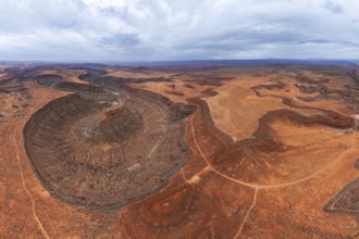 Aerial view of a vast desert landscape showcasing unique geological formations and winding paths in