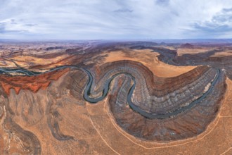 A stunning aerial view captures a meandering river cutting through the rugged San Juan canyon.
