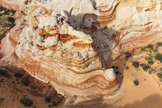 Aerial view overlooking colorful, swirling rock formations in a desert landscape in White Pocket.