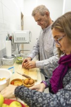 A couple with intellectual disabilities prepares a healthy meal in a cozy kitchen of the supervised