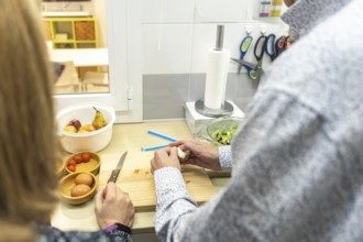 A couple with intellectual disabilities is preparing a healthy meal in a modern kitchen of a