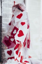 Overflowing mailbox with Valentine's Day envelopes adorned with red and white heart decorations.