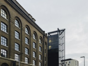 A striking juxtaposition of historic brick architecture with modern glass and steel structures in a