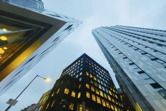 Low-angle view of modern skyscrapers in London at dusk, showcasing their sleek design and