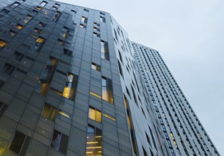 A low-angle view of modern skyscrapers in London, showcasing sleek design and illuminated windows