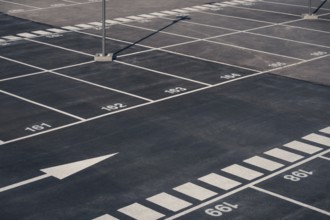 A clear view of numerous empty parking spaces with white numeric markings, located in Valdebebas,